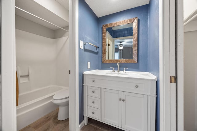 bathroom featuring toilet, vanity, shower / bathing tub combination, and wood finished floors