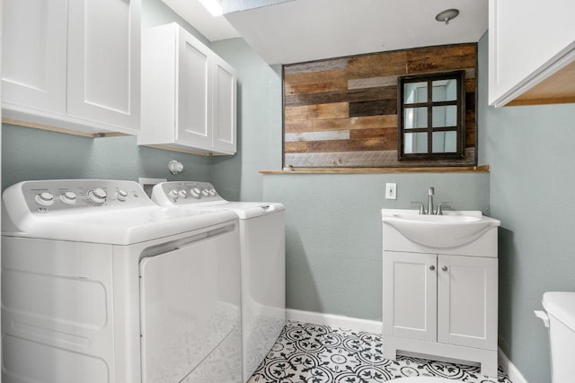 laundry area featuring a sink, washer and dryer, cabinet space, tile patterned flooring, and baseboards