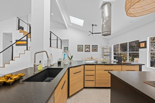 203 Golf Crest Ln, Lakeway, TX 78734 - kitchen featuring a sink, a skylight, dark countertops, light brown cabinetry, and high vaulted ceiling
