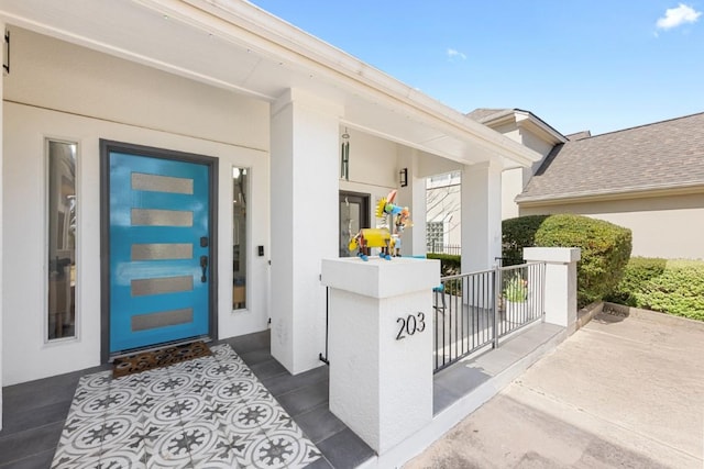 203 Golf Crest Ln, Lakeway, TX 78734 - view of exterior entry featuring stucco siding and a porch