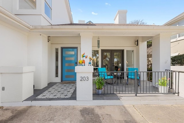 203 Golf Crest Ln, Lakeway, TX 78734 - property entrance with stucco siding, french doors, a porch, and a chimney