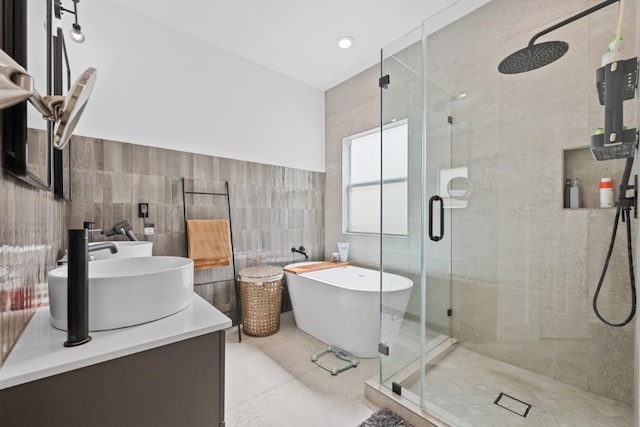 203 Golf Crest Ln, Lakeway, TX 78734 - bathroom with tile walls, a shower stall, a freestanding bath, double vanity, and tile patterned floors