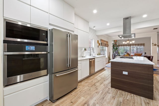 10914 Sierra Oaks, Austin, TX 78759 - kitchen with appliances with stainless steel finishes, a sink, island exhaust hood, light wood-style floors, and white cabinetry