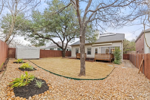 10914 Sierra Oaks, Austin, TX 78759 - back of house with a storage unit, a fenced backyard, a wooden deck, and solar panels