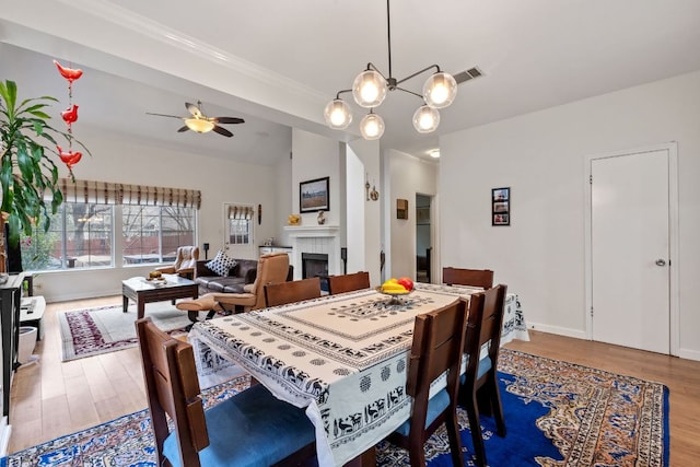 10914 Sierra Oaks, Austin, TX 78759 - dining space with a tile fireplace, a ceiling fan, wood finished floors, baseboards, and vaulted ceiling