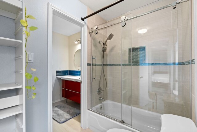 10914 Sierra Oaks, Austin, TX 78759 - bathroom with shower / bath combination with glass door, vanity, toilet, wood finished floors, and baseboards