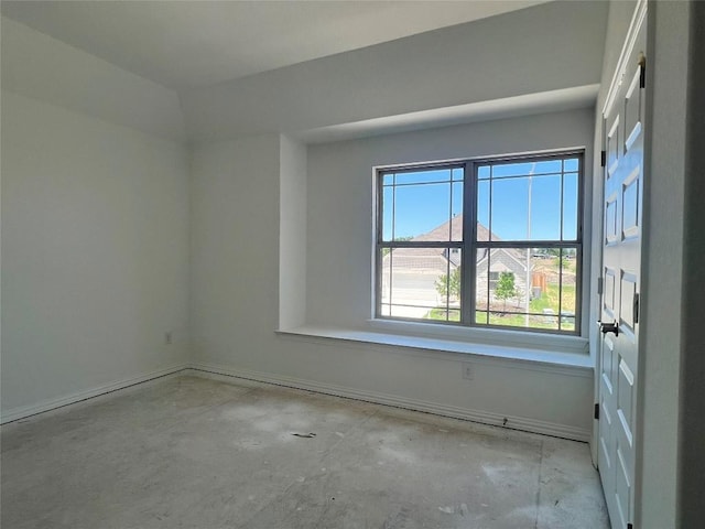 spare room with baseboards and concrete floors