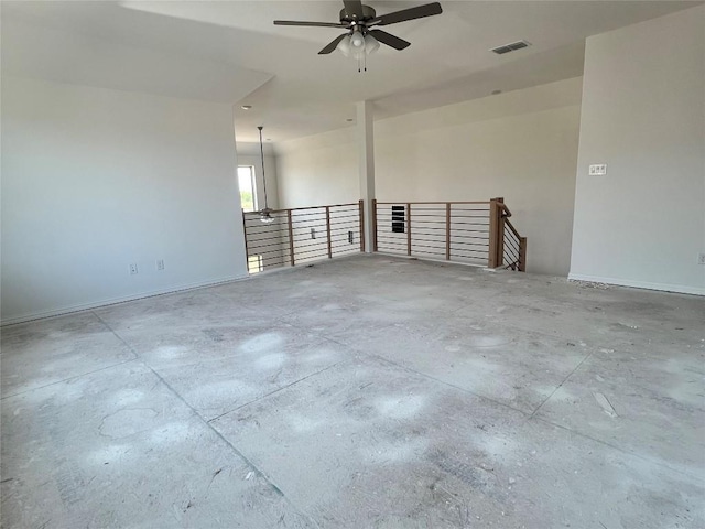 spare room featuring concrete flooring, baseboards, a ceiling fan, and visible vents