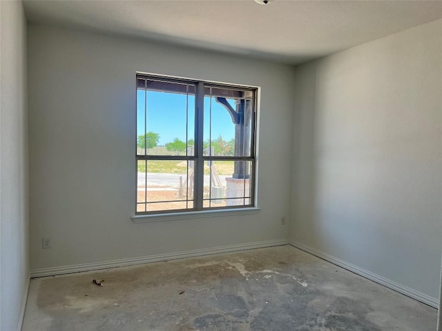 empty room featuring baseboards and concrete floors