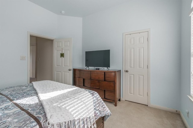 bedroom with baseboards and light colored carpet