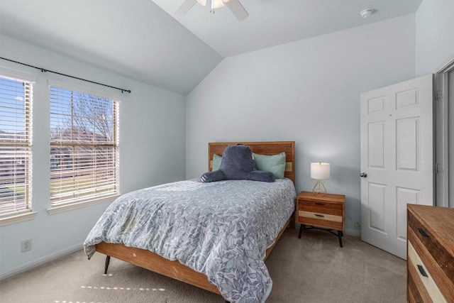 bedroom featuring light carpet, ceiling fan, baseboards, and vaulted ceiling