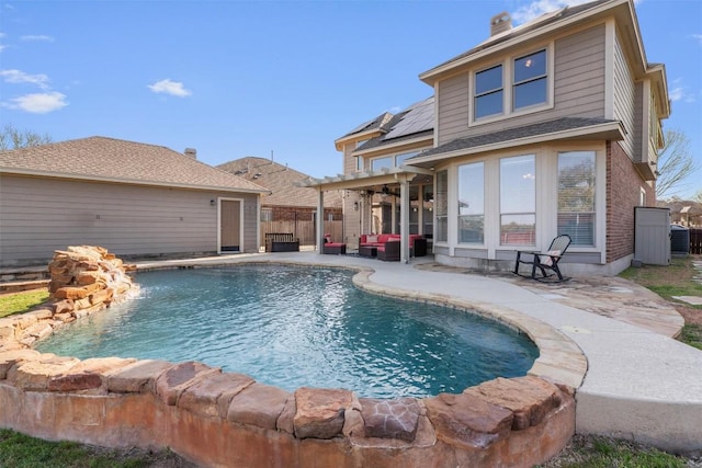 back of house featuring a fenced in pool, solar panels, a fenced backyard, a chimney, and a patio area