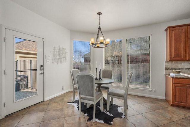 dining space featuring a wealth of natural light, an inviting chandelier, and light tile patterned floors