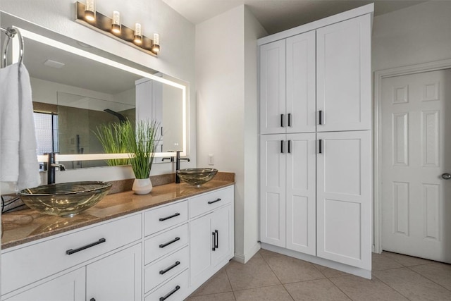 bathroom featuring tile patterned floors, walk in shower, and a sink