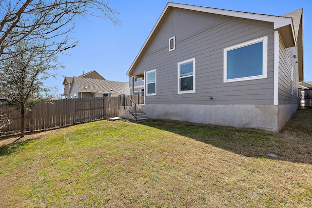 back of property featuring a yard and fence