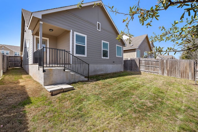 back of house featuring a yard and a fenced backyard