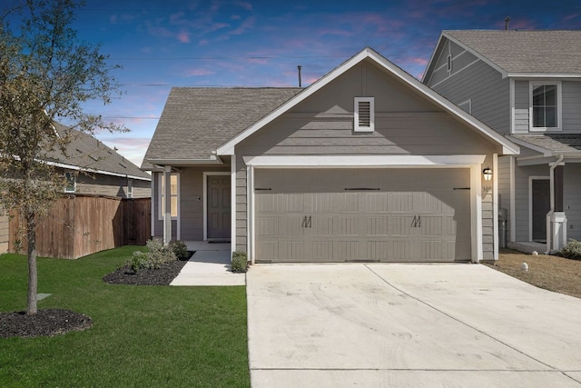 view of front of home featuring a lawn, an attached garage, driveway, and fence