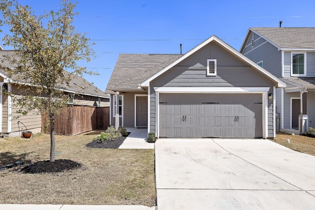 view of front of house featuring concrete driveway, roof with shingles, a garage, and fence