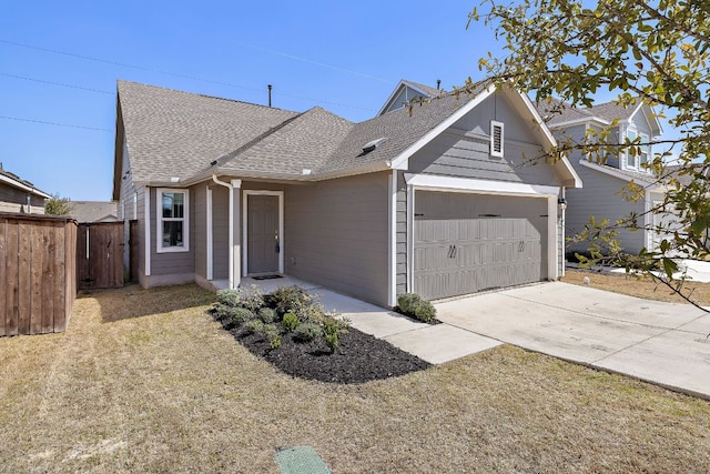 view of front of home featuring an attached garage, a shingled roof, driveway, and fence