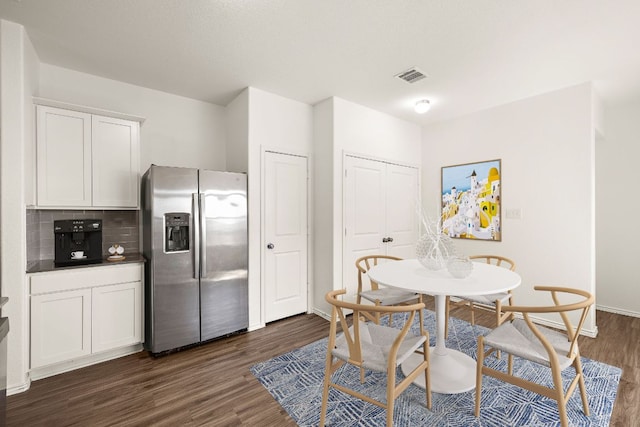 dining space featuring visible vents and dark wood-style flooring