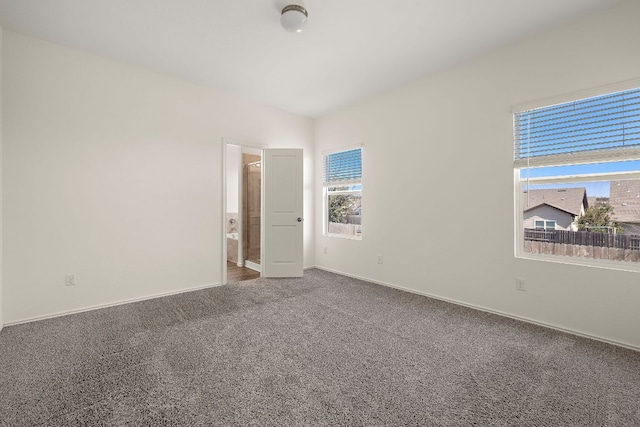 spare room featuring lofted ceiling, baseboards, and carpet floors