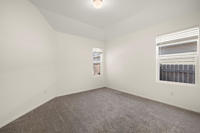 carpeted empty room featuring baseboards