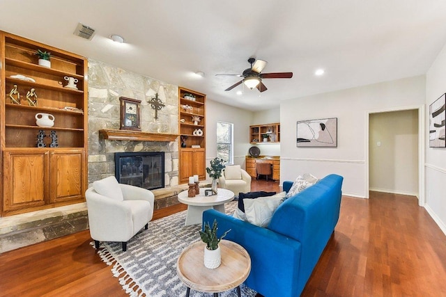 living room with visible vents, a ceiling fan, a fireplace, baseboards, and dark wood-style flooring