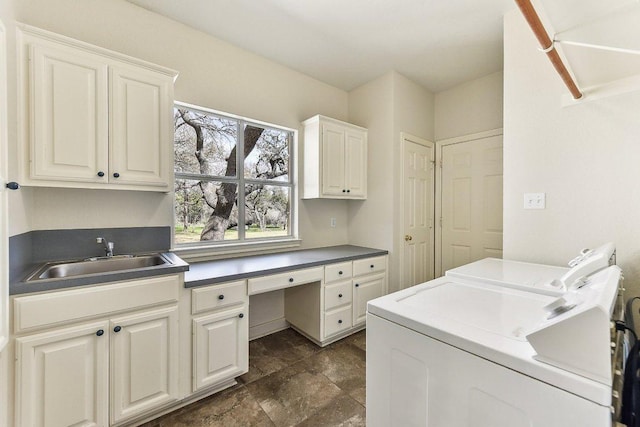 washroom with washer and dryer, stone finish flooring, cabinet space, and a sink