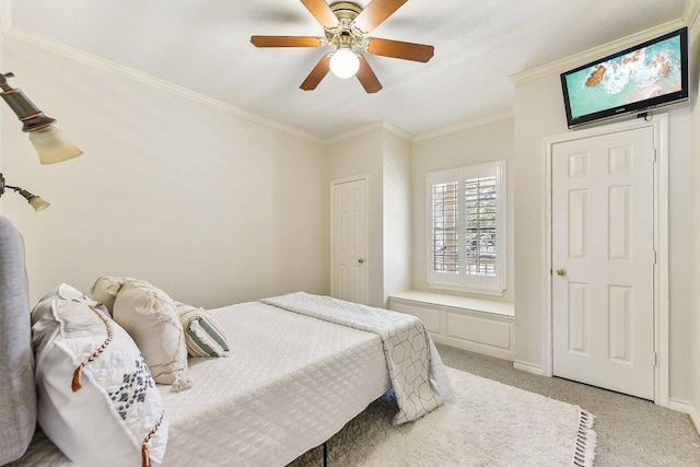 bedroom with baseboards, light colored carpet, ornamental molding, and a ceiling fan