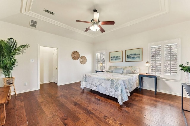 bedroom with visible vents, multiple windows, a raised ceiling, and hardwood / wood-style floors