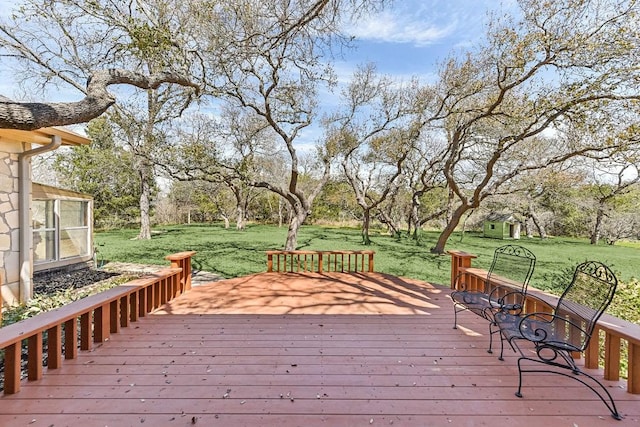 wooden terrace featuring a lawn