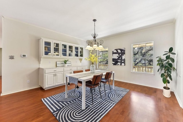 dining room featuring a notable chandelier, dark wood-style floors, and baseboards