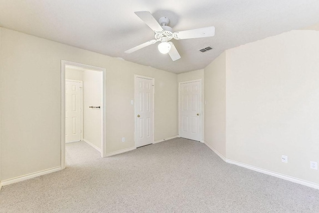 spare room featuring visible vents, light carpet, baseboards, and ceiling fan