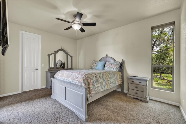 carpeted bedroom featuring multiple windows, baseboards, and ceiling fan