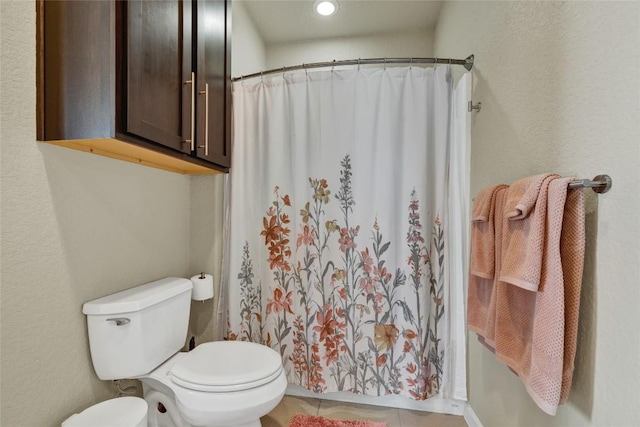 full bath featuring a shower with curtain, toilet, and tile patterned flooring