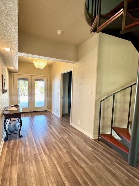 interior space with french doors, baseboards, and wood finished floors