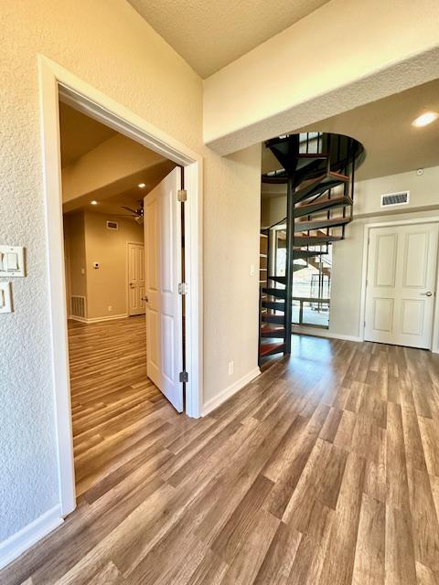 interior space featuring stairway, baseboards, wood finished floors, and a ceiling fan