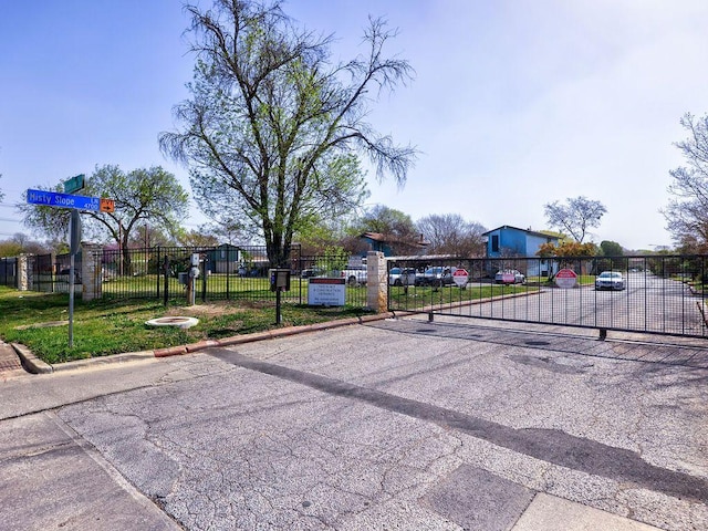 6905 Old Post Loop, Austin, TX 78744 - view of asphalt road with curbs, a gate, and a gated entry
