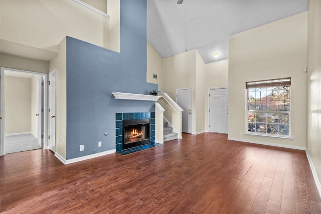 3609 Mims Cv, Austin, TX 78725 - unfurnished living room with a high ceiling, wood finished floors, a tile fireplace, and ceiling fan