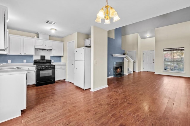3609 Mims Cv, Austin, TX 78725 - kitchen featuring freestanding refrigerator, gas stove, open floor plan, a chandelier, and under cabinet range hood