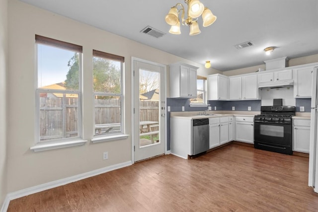 3609 Mims Cv, Austin, TX 78725 - kitchen featuring black range with gas stovetop, dishwasher, a chandelier, light countertops, and healthy amount of natural light