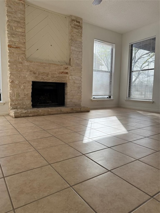 10616 Mellow Meadows Dr Unit 30-D, Austin, TX 78750 - unfurnished living room featuring a fireplace, tile patterned flooring, and a textured ceiling