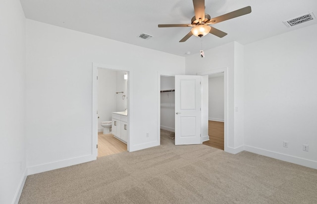 585 Tailwind Dr, Kyle, TX 78640 - unfurnished bedroom with light colored carpet, baseboards, a walk in closet, a closet, and connected bathroom