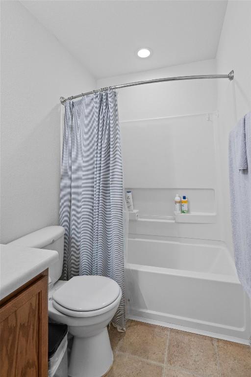 bathroom featuring shower / bath combo, tile patterned floors, toilet, and vanity