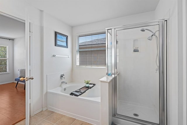 full bath with a shower stall, baseboards, and a garden tub