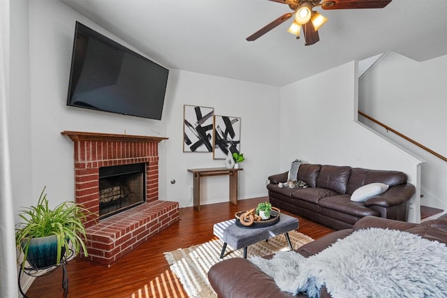 living room featuring a ceiling fan, wood finished floors, and a fireplace