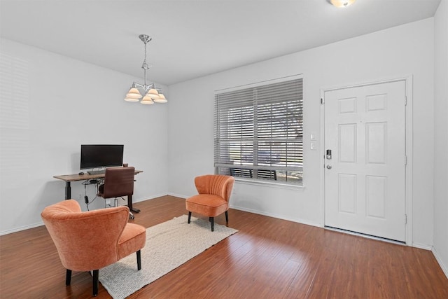 sitting room with baseboards, a chandelier, and wood finished floors
