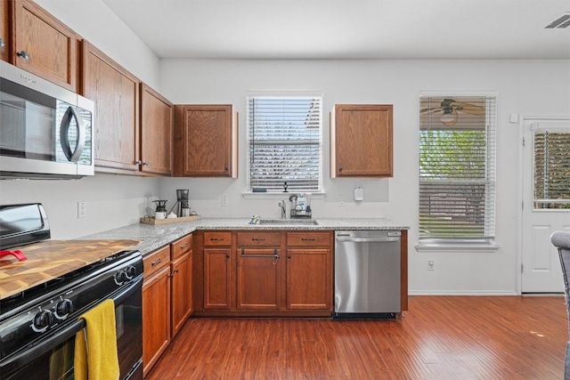 kitchen featuring ceiling fan, a sink, dark wood-style floors, and stainless steel appliances