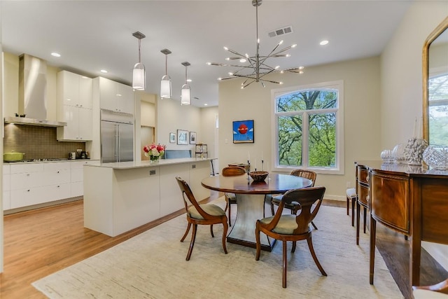 dining area with plenty of natural light, light wood-style floors, visible vents, and a chandelier