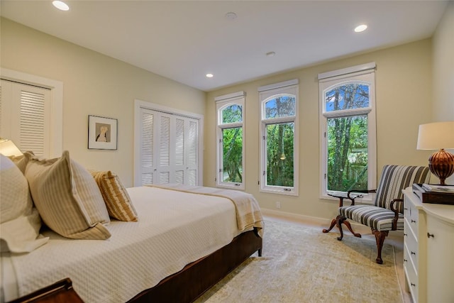 bedroom featuring multiple windows, recessed lighting, and multiple closets